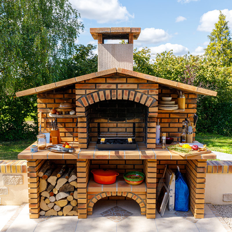 Insert charbon de bois cuisson grill installé dans barbecue béton fixe