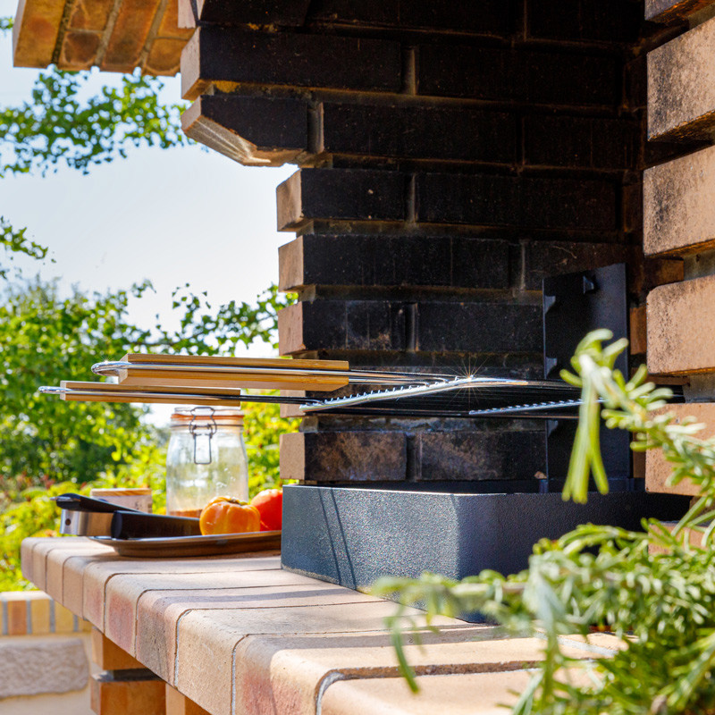 Insert charbon de bois cuisson grill installé dans barbecue béton fixe