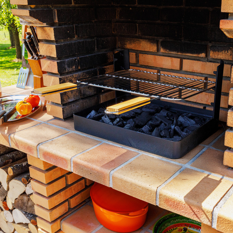 Insert charbon de bois cuisson grill installé dans barbecue béton fixe