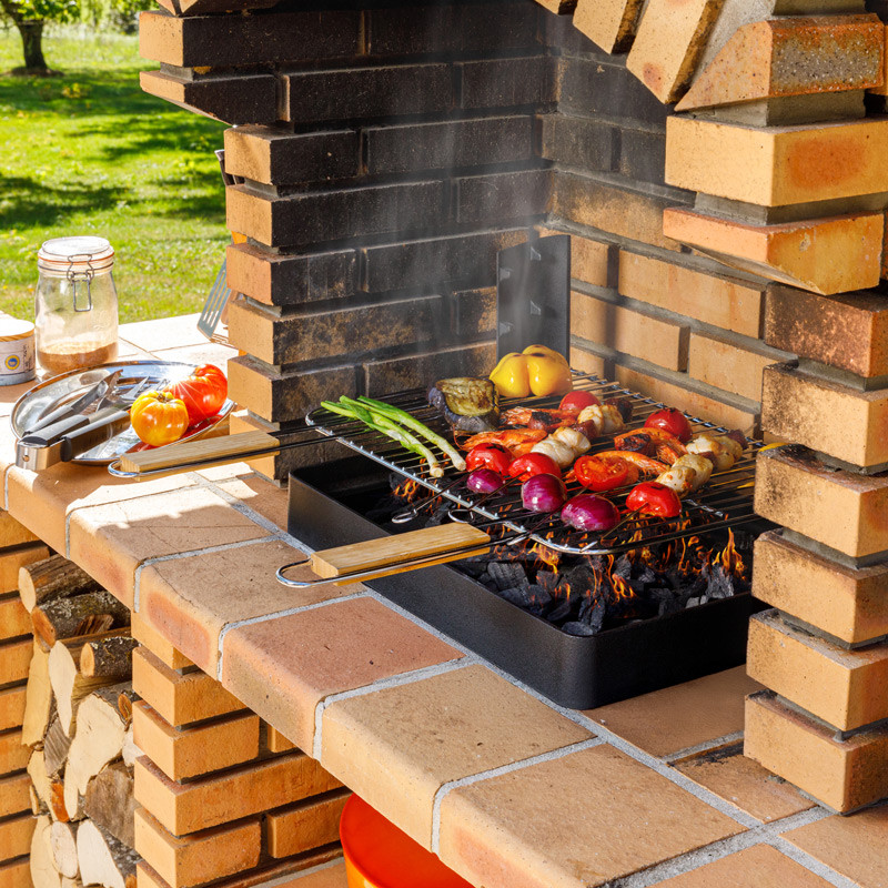 Insert charbon de bois cuisson grill installé dans barbecue béton fixe