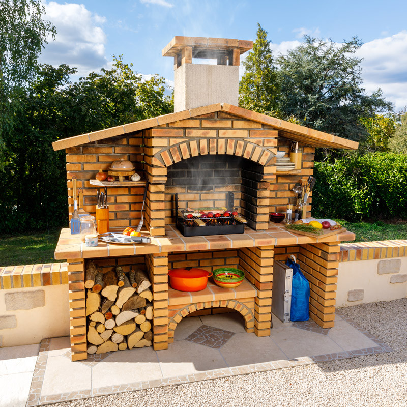 Insert charbon de bois cuisson grill installé dans barbecue béton fixe