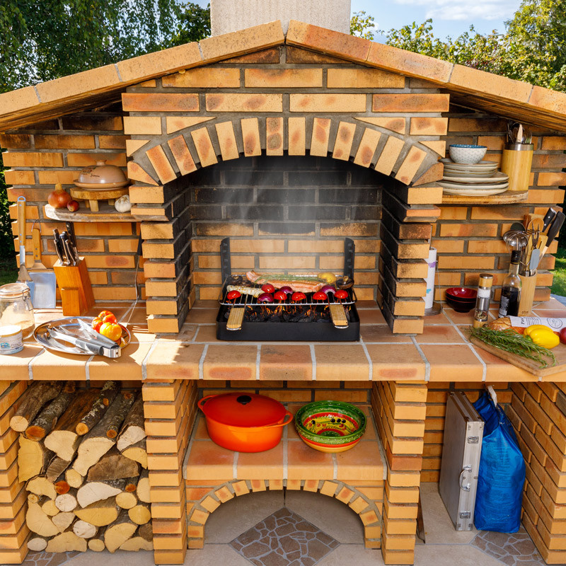 Insert charbon de bois cuisson grill installé dans barbecue béton fixe